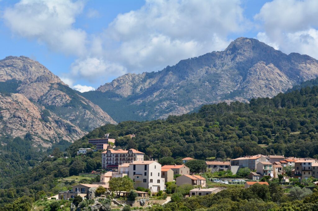 Village corse et montagnes rocheuses sous un ciel nuageux